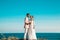 Bride and groom posing on the cliff behind blue sky and sea. Wedding Couple