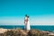 Bride and groom posing on the cliff behind blue sky and sea. Wedding Couple