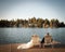 Bride and groom relaxing on lawn chairs on the dock looking out to the lake