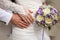 Bride and groom\'s hands with wedding bouquet and rings