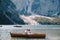 Bride and groom sail in a wooden boat at the Lago di Braies in Italy. Wedding in Europe, on Braies lake. The newlyweds