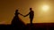 Bride and groom silhouette kissing in beautiful orange-red sunset sky