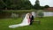 The bride and groom sit on the bench of the old homestead. Shoot camera crane