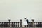 Bride and groom sit on the stone balcony with a deep colored sky