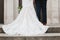 Bride and Groom Stand in Front of Chapel