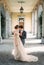 Bride and groom stand hugging on the terrace of an old villa