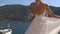 The bride and groom are standing along the pier, groom stroking the back of the bride.