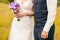 Bride and groom standing on ceremony with wedding bouquet