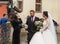 The bride and groom talk with the bridesmaid in front of the church in the Small Square. Sibiu city in Romania