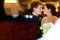 Bride and groom touch with noses sitting in the restaurant