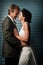 Bride and Groom touching noses against a blue wall