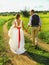The bride and groom walk along the path. The groom holds the bride`s hand. love road