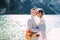 The bride and groom walk along a wooden boat dock at the Lago di Braies in Italy. Wedding in Europe, on Braies lake