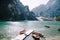 The bride and groom walk along a wooden boat dock at the Lago di Braies in Italy. Wedding in Europe, on Braies lake