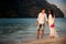 Bride and groom walk at beach at dawn