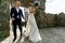 Bride and groom walk dancing into the stone courtyard