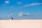 Bride and groom walk in the desert, view from afar
