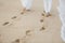 The bride and groom walk hand in the sand. footprints in the sand near the ocean.