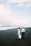 Bride and groom walking along Vik beach in Iceland