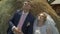 Bride and groom walking and holding hands on a meadow. Wide angle sunset photo