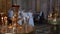 Bride and groom at wedding ceremony in church holding candles in hands.