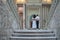 Bride and groom in wedding costumes stand on the stairs in the wedding palace rear view, Horizontal