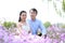 Bride and groom in wedding dress with elegant hairstyle Sitting in Orychophragmus violaceus flower field