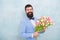 Bride groom at wedding party. bearded man in bow tie with tulip flowers. womens day. Formal mature businessman spring