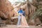 Bride and groom wrapped in flag of Ukraine are kissing in canyon.