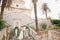 The bride and groom in wreaths stand hugging on the stairs of the Nativity of the Blessed Virgin Mary church in Prcanj