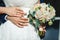 Bride hands with ring . Newlyweds put their hands on the bouquet