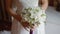 Bride held wedding bouquet in her arms