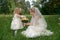 Bride with her daughter together with a bouquet on green summer