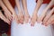 Bride and her girlfriends stand side by side and show their hands