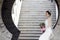 Bride hold bridal bouquet with white wedding dress near a brick arch