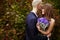 Bride hold a wedding bouqet behind her chest while groom kisses