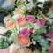 Bride holding a beautiful bridal bouquet. Wedding bouquet of peach roses by David Austin, single-head pink rose aqua, eucalyptus