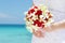 Bride holding bridal bouquet on natural sea background