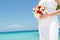 Bride holding bridal bouquet on natural sea background