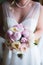 Bride is holding delicate pink bridal bouquet