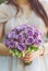 Bride holding her bouquet of purple roses