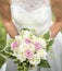 Bride holding pink and white wedding flowers