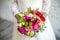 Bride holding rose pink wedding bouquet of roses and love flowers