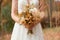 bride holding a wedding bouquet with golden blooms