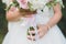 The bride is holding a wedding bouquet. Large view of hands