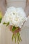 Bride holding wedding bouquet. White peony flowers. Classical elegance.