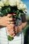 Bride holding white wedding bouquet of roses and love flower