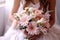 bride holds a beautiful wedding bouquet of pink and white flowers