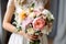 bride holds a beautiful wedding bouquet of pink and white flowers