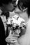 Bride holds a bouquet in hands in white gloves while groom kiss